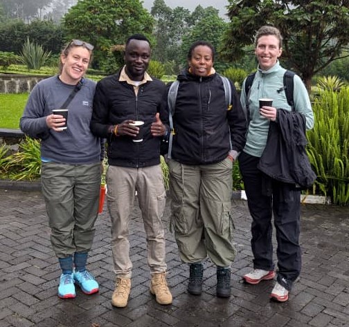 Second from the left, Mukalazi Sam—Smiling with Tourists